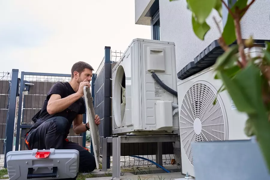 Instalator podczas montażu jednostki zewnętrznej klimatyzatora przy
budynku